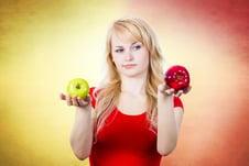 Mujer con dos manzanas de distinto color
