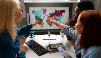 persones assenyalant el mapa del món